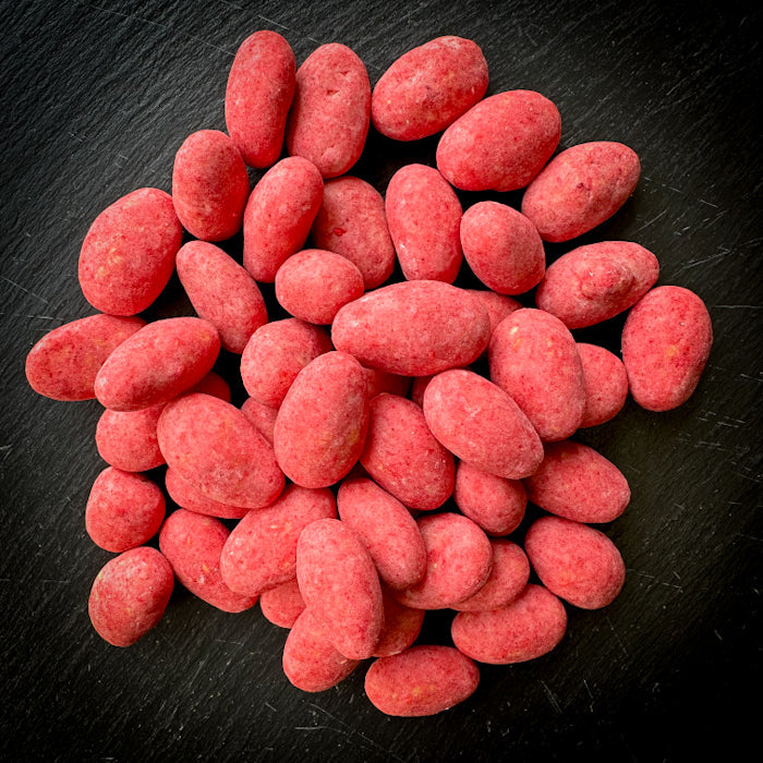 Kraukšķīgas mandeles rozā šokolādē ar aveņu garšas noti