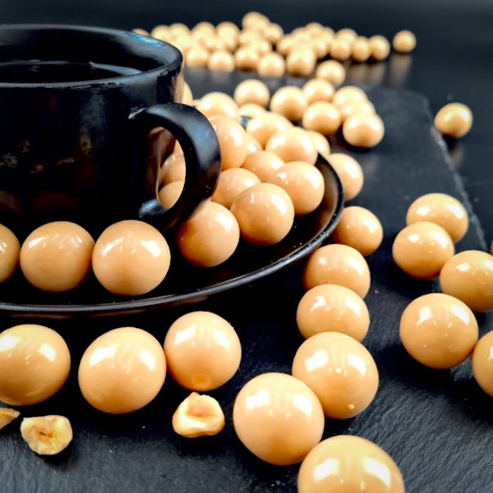 Kapučino dražejas ar lazdu riekstiem baltā beļģu šokolādē